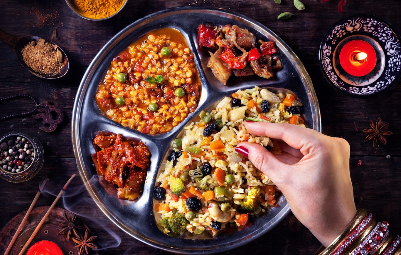 Mujer india comiendo con la mano durante Diwali