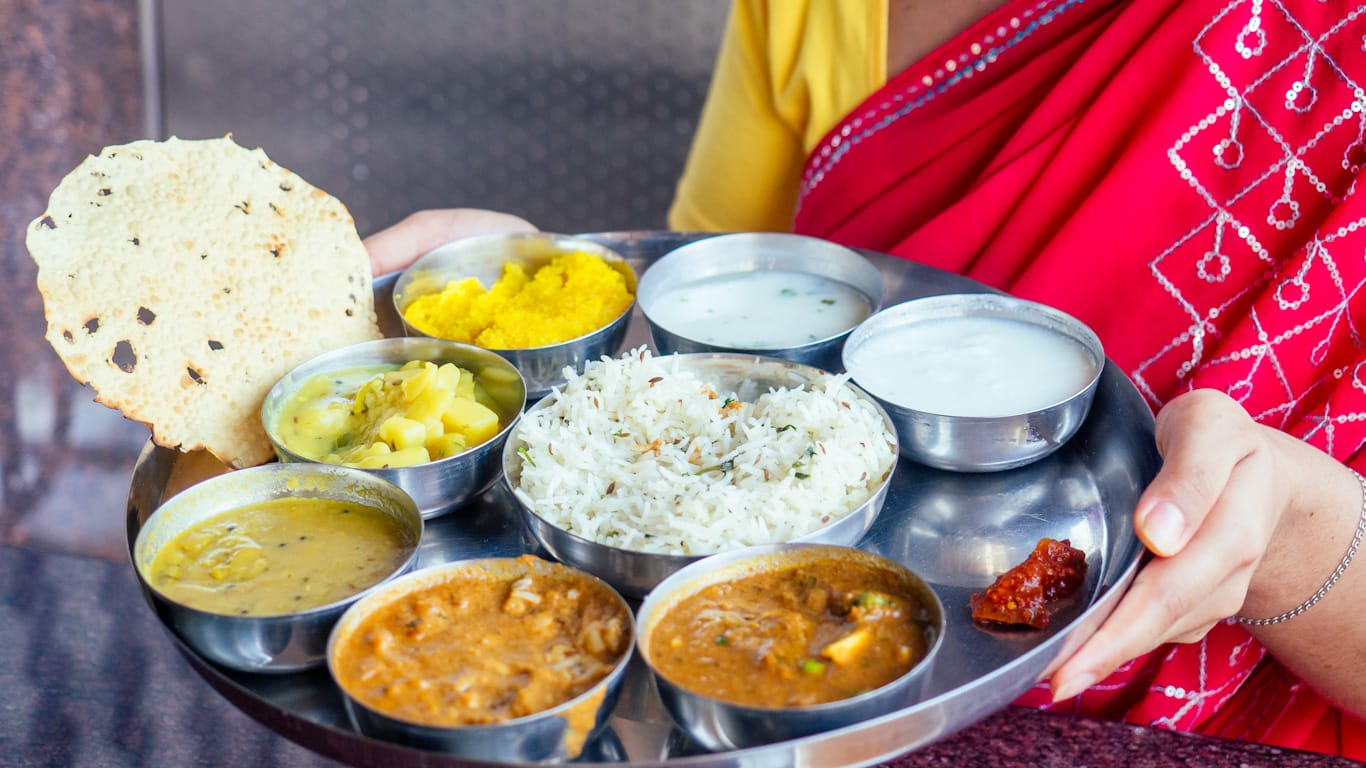 Mujer sirviendo un Thali del Norte de la India